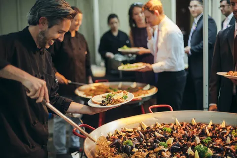 Paella House catering staff serving paella to guests at an event